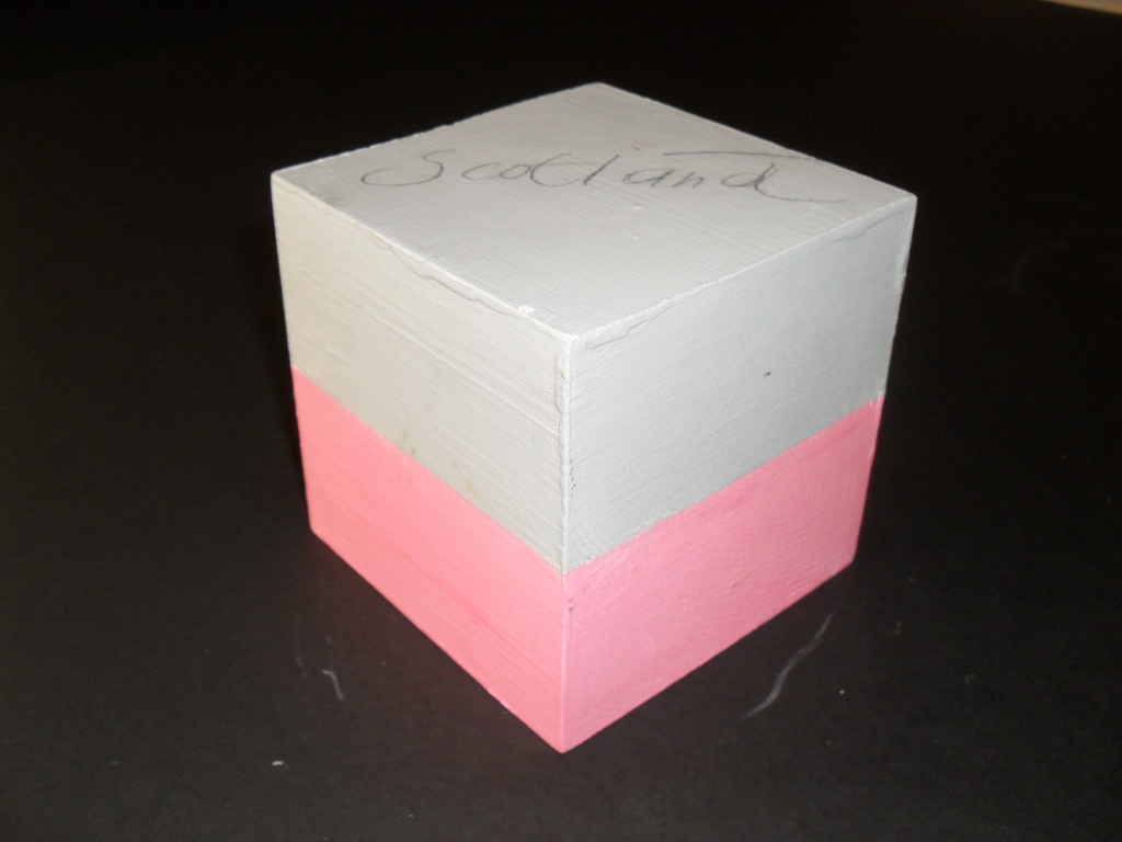 Cube painted pink and grey with "Scotland" and "India" DUNIH 2011.1.28