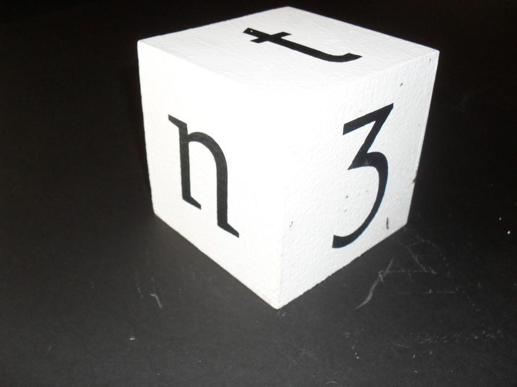 Cube painted white with letters and number 3 in black. DUNIH 2011.1.30