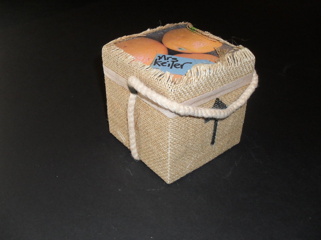 Cube wrapped in jute with top showing image of oranges DUNIH 2011.1.67