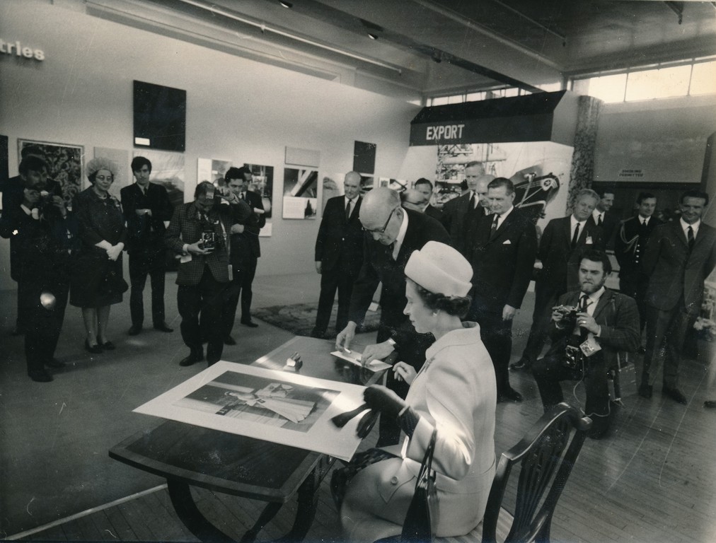 Photograph of the Queen signing an image of herself, May 1969 DUNIH 2017.16.2.32