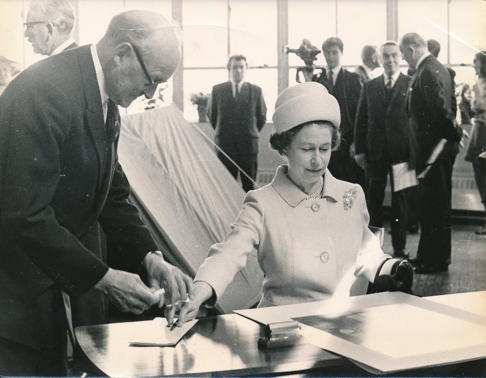 Photograph of the Queen signing an image of herself, May 1969 DUNIH 2017.16.2.33