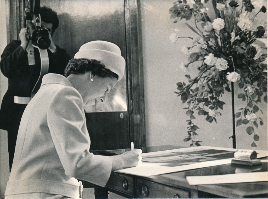 Photograph of the Queen signing an image of herself, May 1969 DUNIH 2017.16.2.34