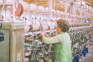 Image of Woman working on a spool winding machine DUNIH 2006.1.13.13