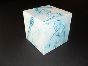 Image of Cube covered in paper with blue figures in shrouds. DUNIH 2011.1.60